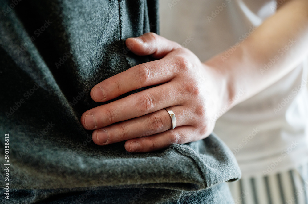 Close up of man's hand on his wife's waist Close up of man's hand on his wife's waist