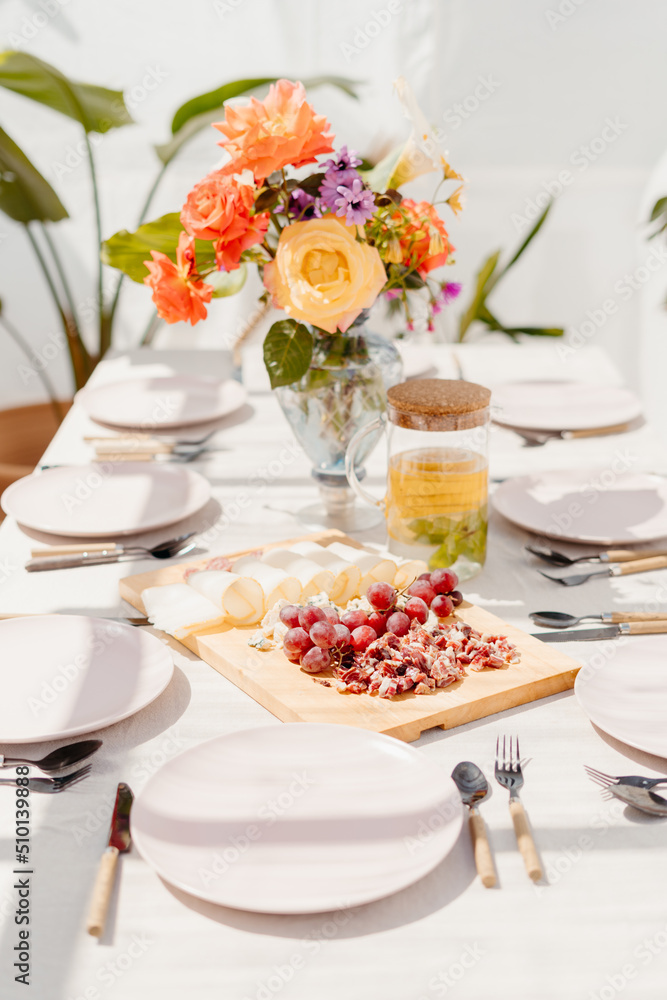 Lunch table at terrace with decorative bouquet Lunch table at terrace with decorative bouquet