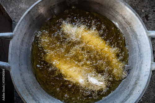 Fresh fish being fried in a pan outdoors