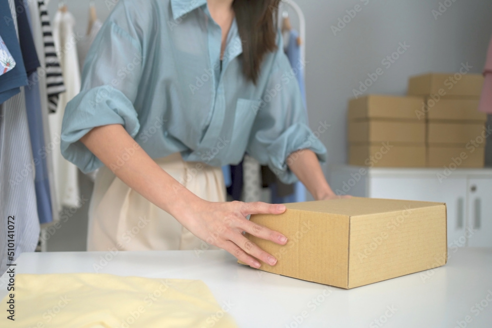 Happy Asian young woman showing a cardboard parcel box to camera, online selling or e-commerce concept. Happy Asian young woman showing a cardboard parcel box to camera, online selling or e-commerce concept.