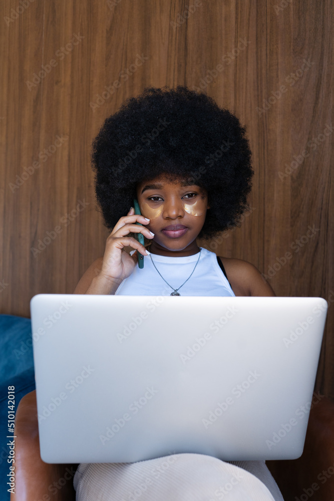 Female freelancer having phone conversation in armchair Female freelancer having phone conversation in armchair