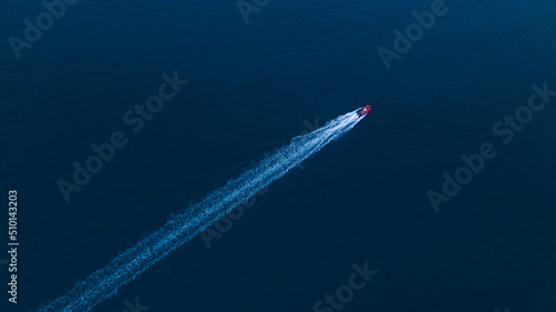 drone view of a motorboat racing fast in the dusk