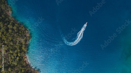 drone view of a turning speedboat in azure water photo