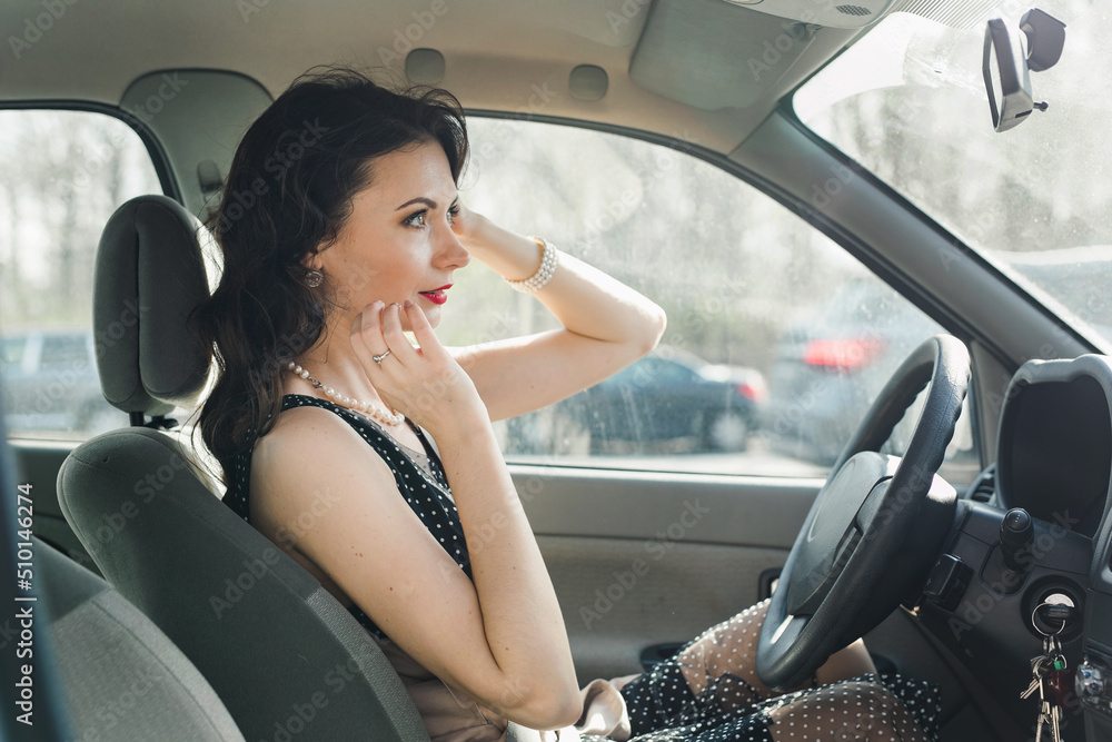 Woman adjusting herself looking in a rear view mirror in a car Woman adjusting herself looking in a rear view mirror in a car