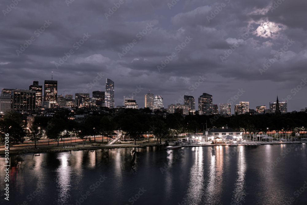 Obraz premium Boston city Charles River at dusk with urban skyline and skyscrapers.