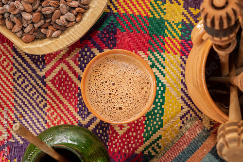 A cup of a traditional Oaxacan chocolate next to molinillos photo