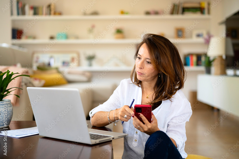 Female freelancer with smartphone reading data Female freelancer with smartphone reading data
