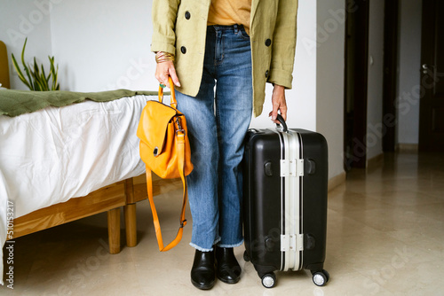 Cropped woman with travel suitcase  photo