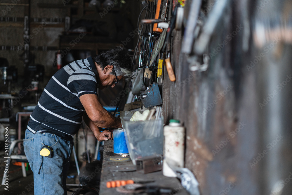 old man looking for tools in the workshop old man looking for tools in the workshop