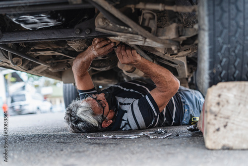 Man mechanic under a car repairing