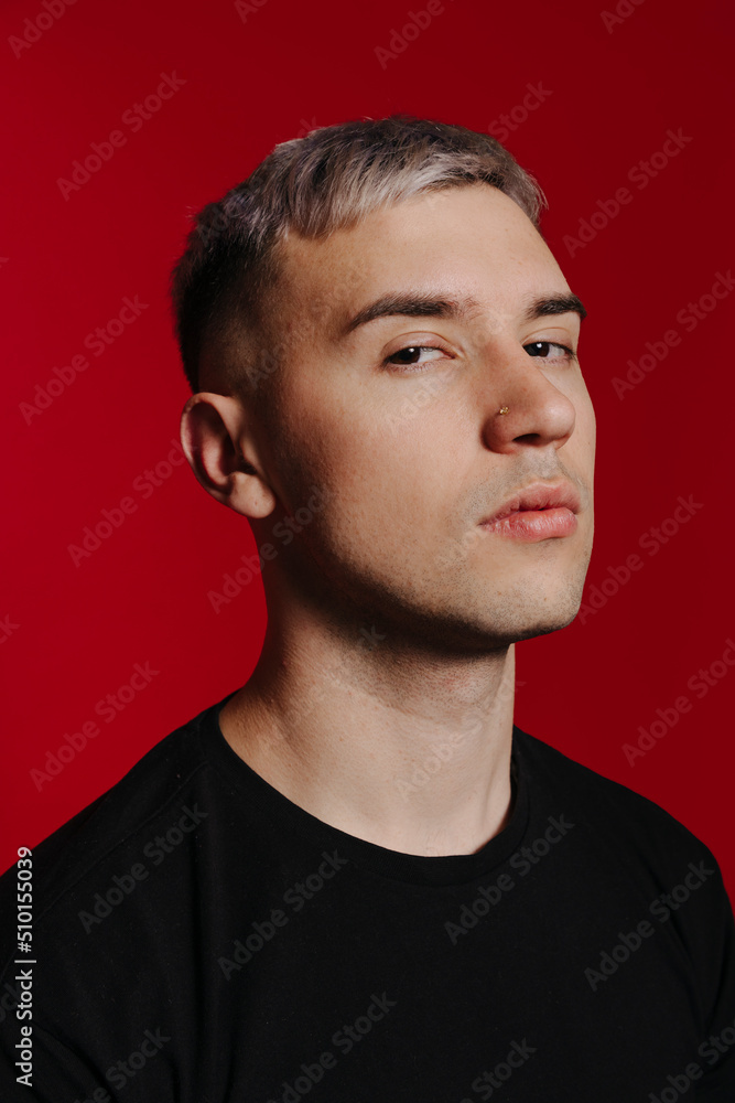 Serious young man on red background in studio Serious young man on red background in studio