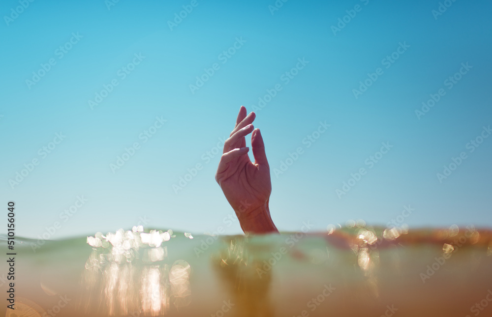 Surreal female hand coming out of the water Surreal female hand coming out of the water
