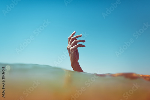 Surreal hand emerging from the ocean photo