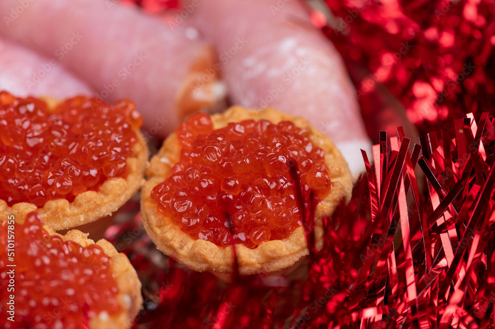 Salmon caviar in a tartlet on a glass dish. Festive table setting Salmon caviar in a tartlet on a glass dish. Festive table setting