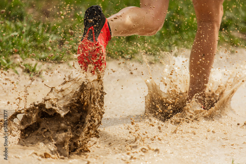 runner splashes on muddy track photo