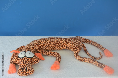 Leopardo acostado , juguete , animal , de tela , suave , blando, marrón , naranja , negro , azul , blanco , regalo , divertido, jugar , niños , abrazo , regalar 