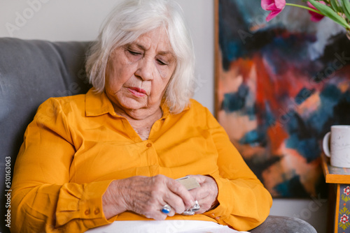 Senior woman reading cards at home photo