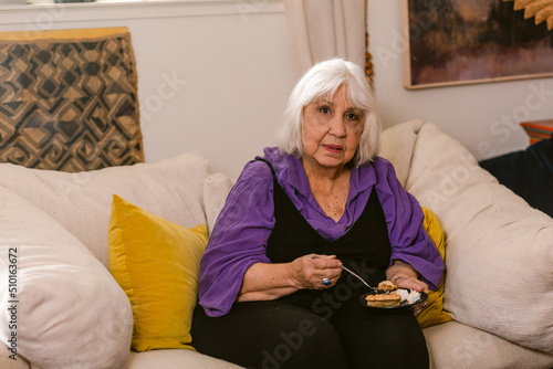 Adorable elderly woman having cake at home photo