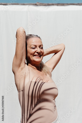 Positive woman shaded by palm leaf outdoor