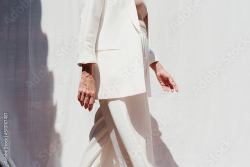 Cropped elegant woman in white suit outdoor photo