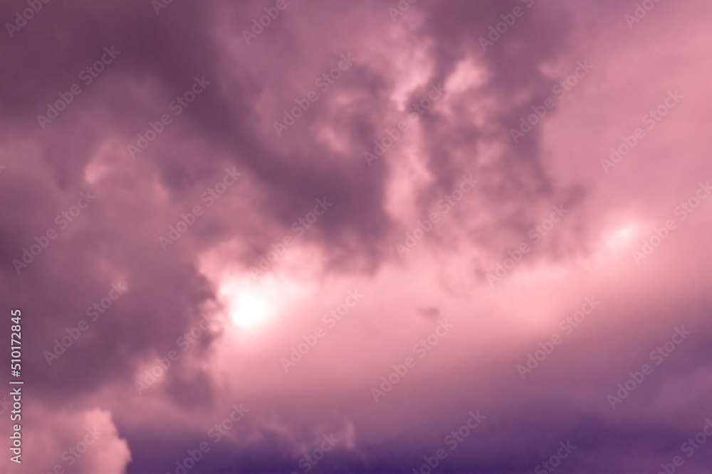 Dramatic stormy sunset sky with fluffy clouds.  Blurred photo of purple sky background. 