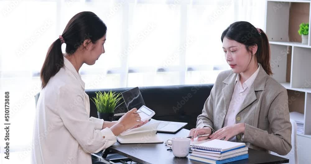 Portrait of Asian office employee businesswoman working in an office, doing planning analyzing the financial report, business plan investment, finance analysis concept. Office background.
