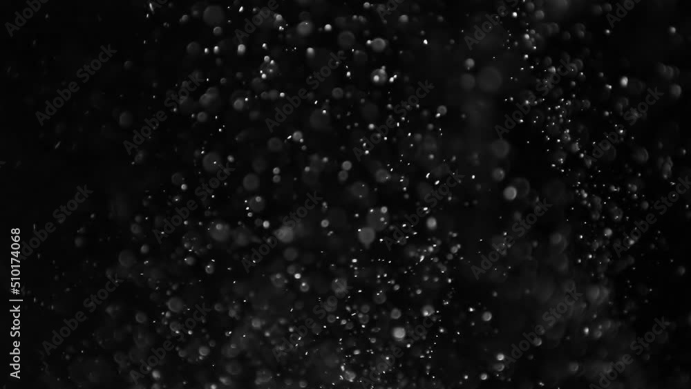 Rising dust particles on black background. Slow motion. Rising dust particles on black background. Slow motion.