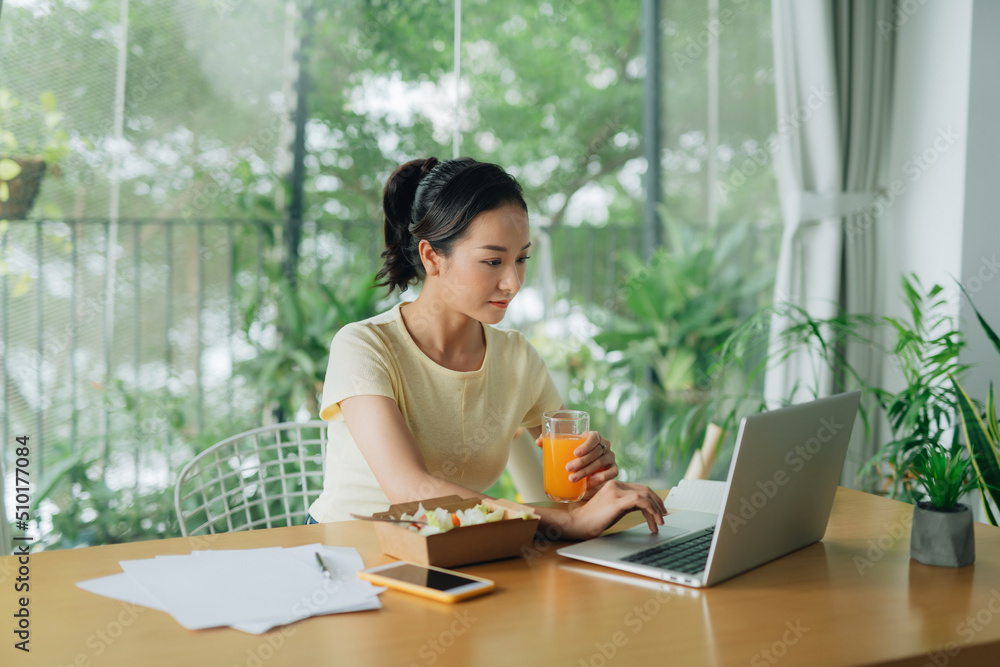 Pretty young business woman eating healthy salad in office Pretty young business woman eating healthy salad in office