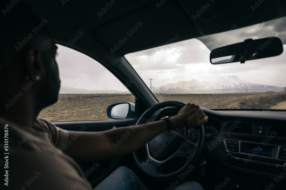 Man driving a car near Mount Hasan Man driving a car near Mount Hasan
