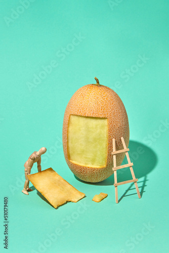 Wooden mannequin model holds part of melon peel. photo