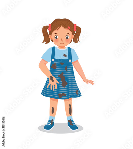 cute little girl looking at dirty muddy stain on her clothes after playing in the field outside