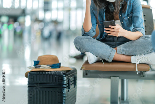 attractive asian female traveller wear casula cloth headphone using laptop for wating flight departure at airport terminal,asian female smile hand waving greeting looking at camera travel idea concept photo