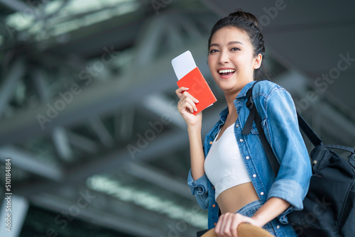 smiling asian female relax carefree casual cloth walking at airport hand hold boarding pass and luggage bag summer travel vacation lifestyle,asia digital nomad expat work and travel photo