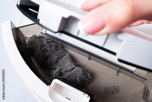 Dust, debris, lint and hair in the vacuum cleaner's dust container. The need for frequent house cleaning to avoid allergies photo