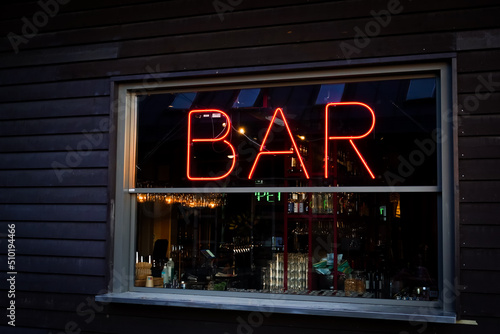 Photography Bar sign in red neon light in a window on a dark wall