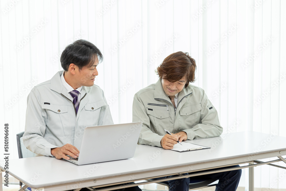 Obraz premium 打ち合わせをする作業着をきたビジネスマン 