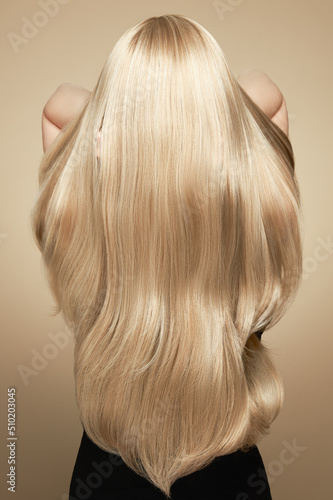 Canvas Print Back view of woman with long beautiful blond hair isolated on beige background
