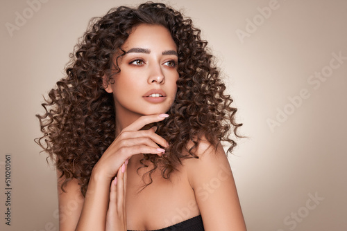Fashion studio portrait of beautiful smiling woman with afro curls hairstyle. Fashion and beauty photo
