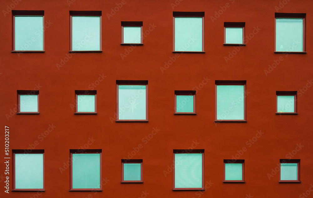 Naklejka premium Different size windows on a red facade