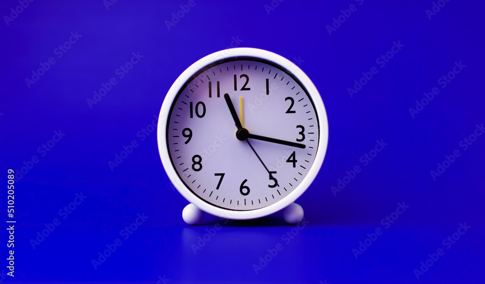 white alarm clock set on a blue background time concept and waking up white alarm clock set on a blue background time concept and waking up