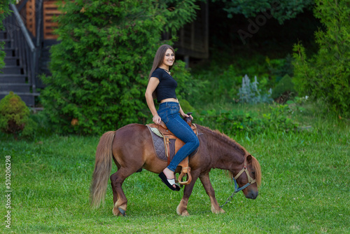 woman riding a pony on the lawn © zokov_111