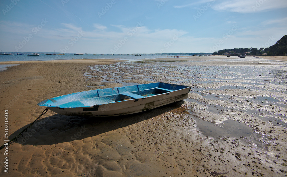 Blue boat on the sand beach during ebb, Brittany, France.