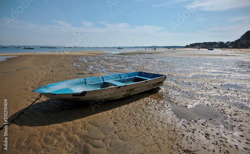 Blue boat on the sand beach during ebb, Brittany, France.