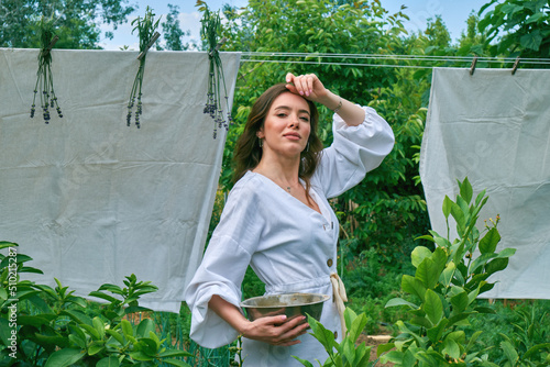 A young woman hangs out laundry outdoors.