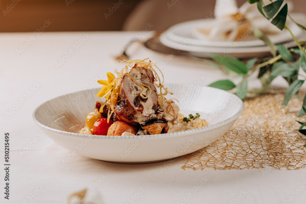 Meat roll with prunes is served on a pillow of vegetables and rice in restaurant Meat roll with prunes is served on a pillow of vegetables and rice in restaurant