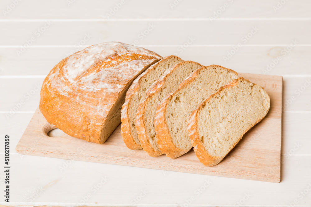 Assortment of freshly sliced baked bread with napkin on rustic table top view. Healthy unleavened bread. French bread slice Assortment of freshly sliced baked bread with napkin on rustic table top view. Healthy unleavened bread. French bread slice