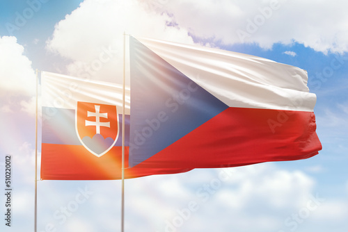Foto Sunny blue sky and flags of czechia and slovakia