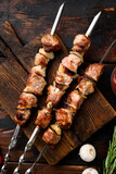 Shish kebab BBQ meat with onions and tomatoes, on old dark  wooden table background, top view flat lay