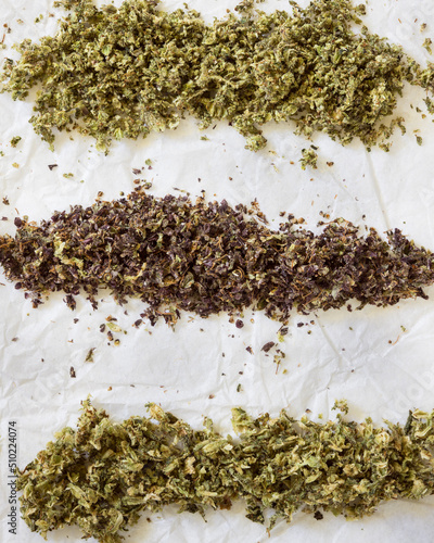 Cannabis bud ground up and ready to roll. Purple and green marijuana stripes with light background
