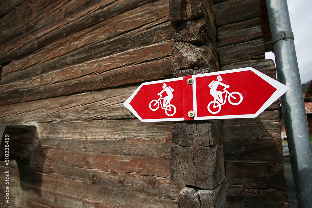 Red Sign With Pointer Of Bicycle Route Attached To The Vintage Wooden red-sign-with-pointer-of-bicycle-route-attached-to-the-vintage-wooden